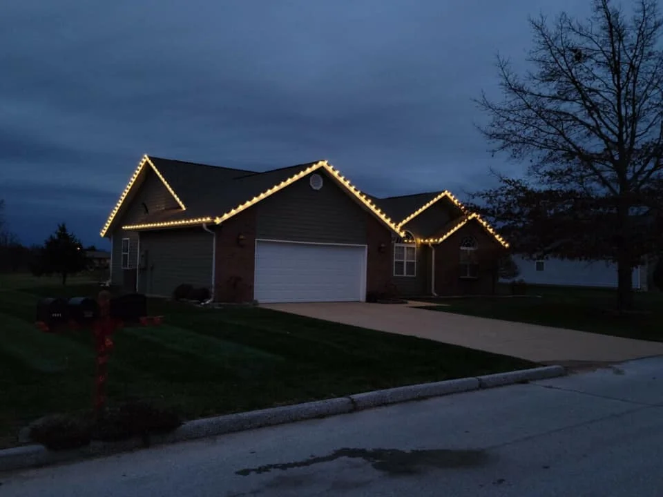 Warm Christmas lights tracing the roof peaks of a home in Nightingale’s existing gallery